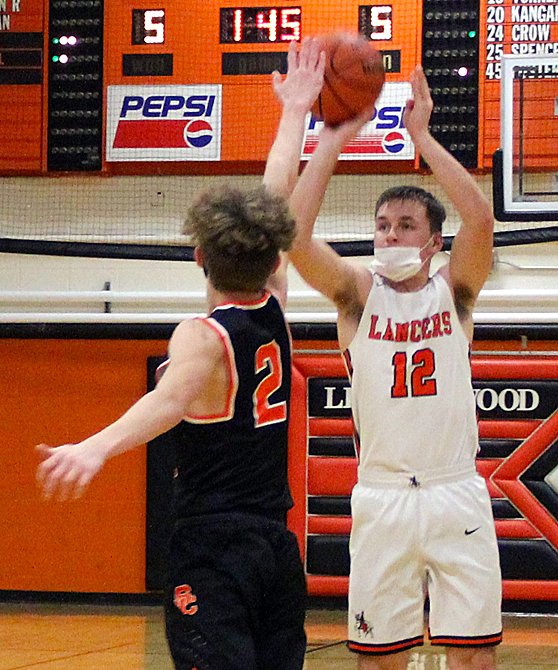 Lincolnwood's Will Jenkins (#12) shoots a three over the outstretched hand of South County's Trenton Sampson during the Lancers' 45-35 loss to the Vipers on Feb. 19.