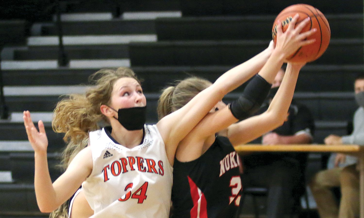 Hillsboro's Alex Frailey (#34) tries to pry away a rebound from Nokomis' Emily Cress during the Montgomery County clash on Wednesday, Nov. 17. Frailey finished with 13 points in the Toppers' 44-29 win over the Redskins, their ninth straight against their neighbors along Rt. 16.