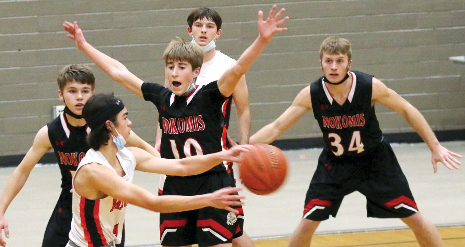 Mason Stauder (#10), accompanied by Nokomis teammates Kamron Coss (left) and Jake Johnson (#34), pestered Bryan Jubelt and the Gillespie offense throughout Tuesday’s game in Gillespie, holding the Miners without a field goal for the first 10 minutes of the game. Gillespie would come back to tie the contest in the second half, but Nokomis persevered the rally and picked up a 50-40 win.