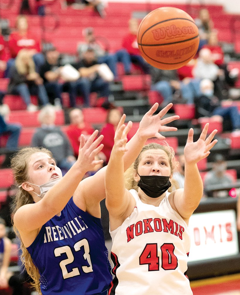 Greenville's Abby Sussenbach (#23) and Nokomis' Cydney Bertolino (#40) battle for a rebound during the 5 p.m. game at the T. Todt Shootout in Nokomis on Saturday, Dec. 11. Less than two weeks after beating the Comets by three in regulation, Nokomis knocked off Greenville again, this time 42-37 in overtime.