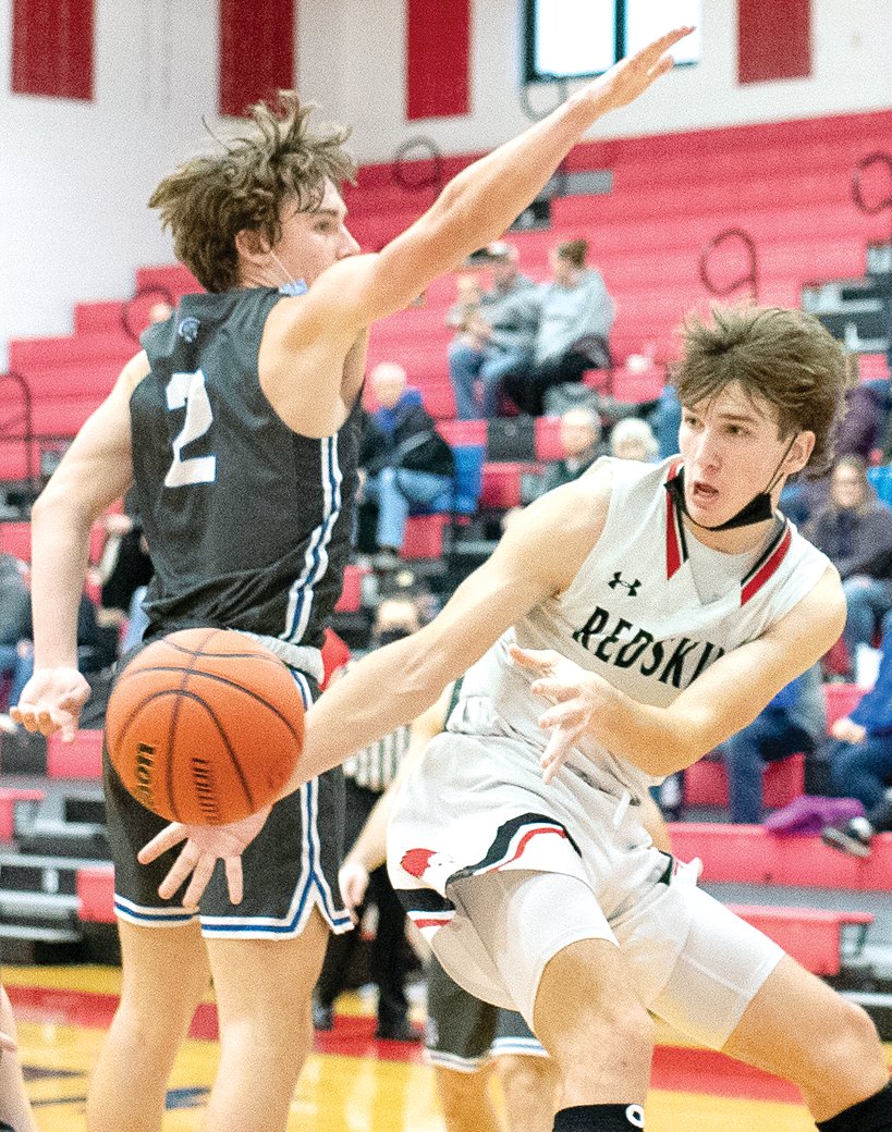 Nokomis' Elijah Aumann drives and dishes late in the fourth quarter of the Redskins' game with Auburn on Saturday, Dec. 18. Aumann led the team in points (18) and assists (4) as the Redskins knocked off the Trojans 60-45 in Nokomis.