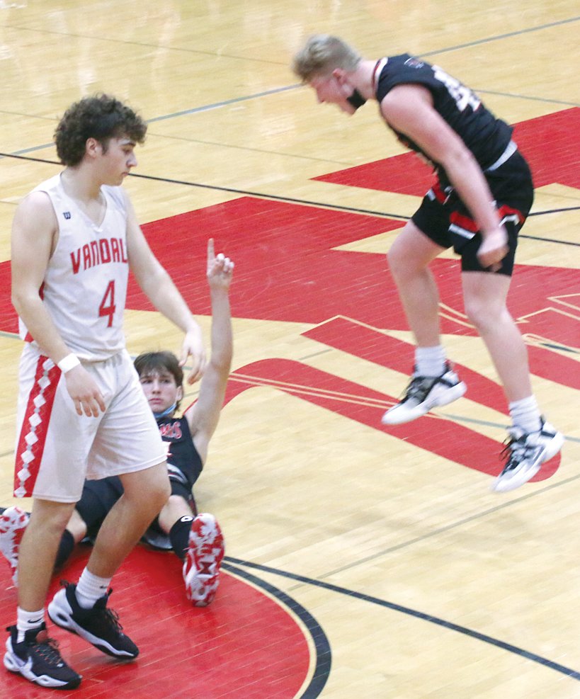 Seconds before being mauled by teammate Ryan Eisenbarth (right), Nokomis' Elijah Aumann points skyward after hitting an off-balance fadeaway buzzer beater that gave the Redskins a 53-51 victory over Vandalia in the fifth place game of the Vandalia Holiday Tournament on Thursday, Dec. 30.