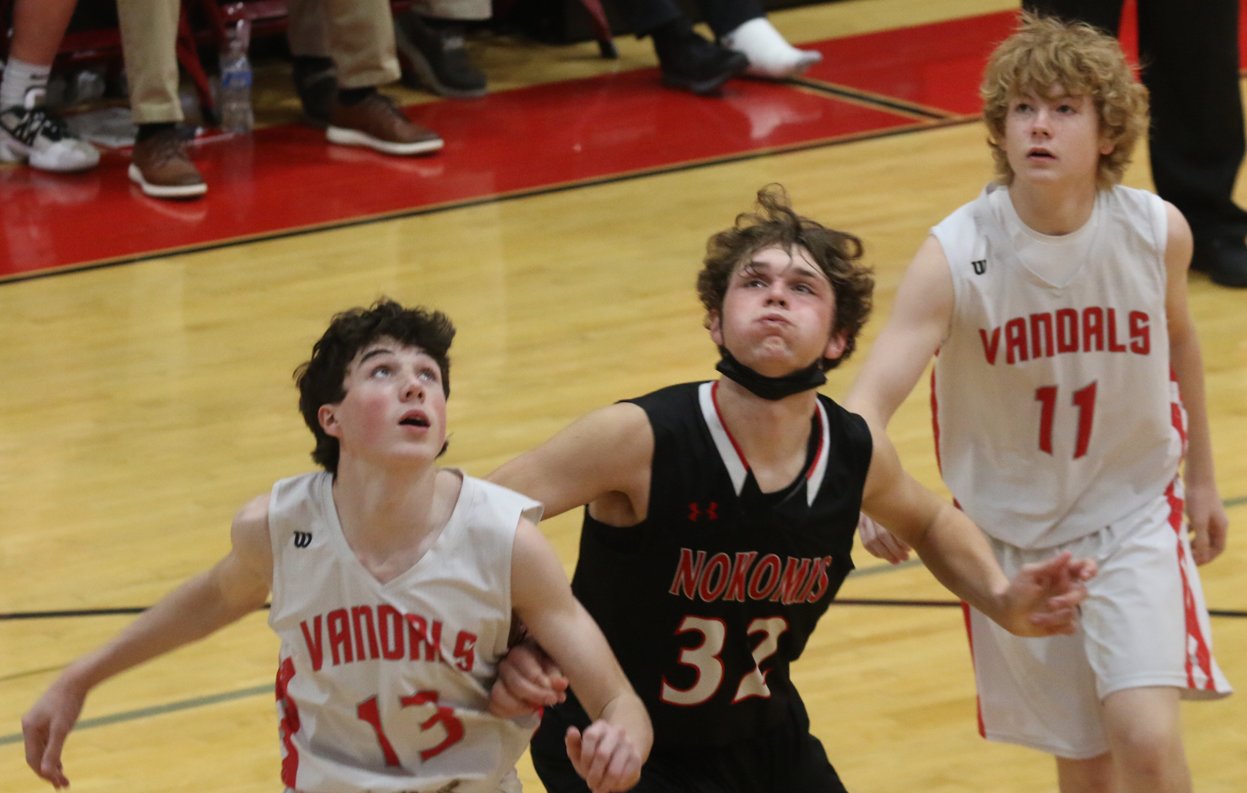 Sandwiched between Vandalia's Preston Nestrick (#13) and Chase McNary (#11), Nokomis' Cooper Bertolino awaits the result of a Nokomis free throw during the fifth place game at the Vandalia Holiday Tournament on Thursday, Dec. 30. Bertolino had four of his nine points in the fourth quarter to help Nokomis to a 53-51 win over the Vandals in a game that ended with an Elijah Aumann go-ahead buzzer beater.