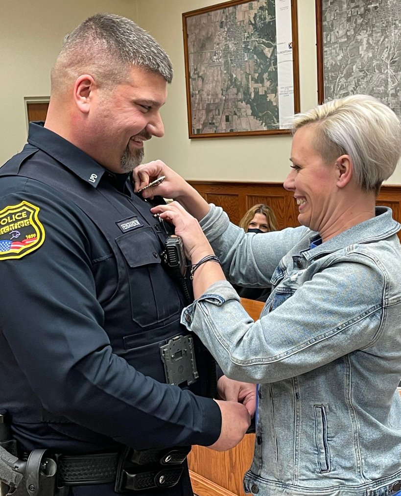 Jenny Fergurson pins on her husband Quincy’s new badge at the Litchfield City Council meeting on Thursday, Jan. 6, after Fergurson was promoted to sergeant.